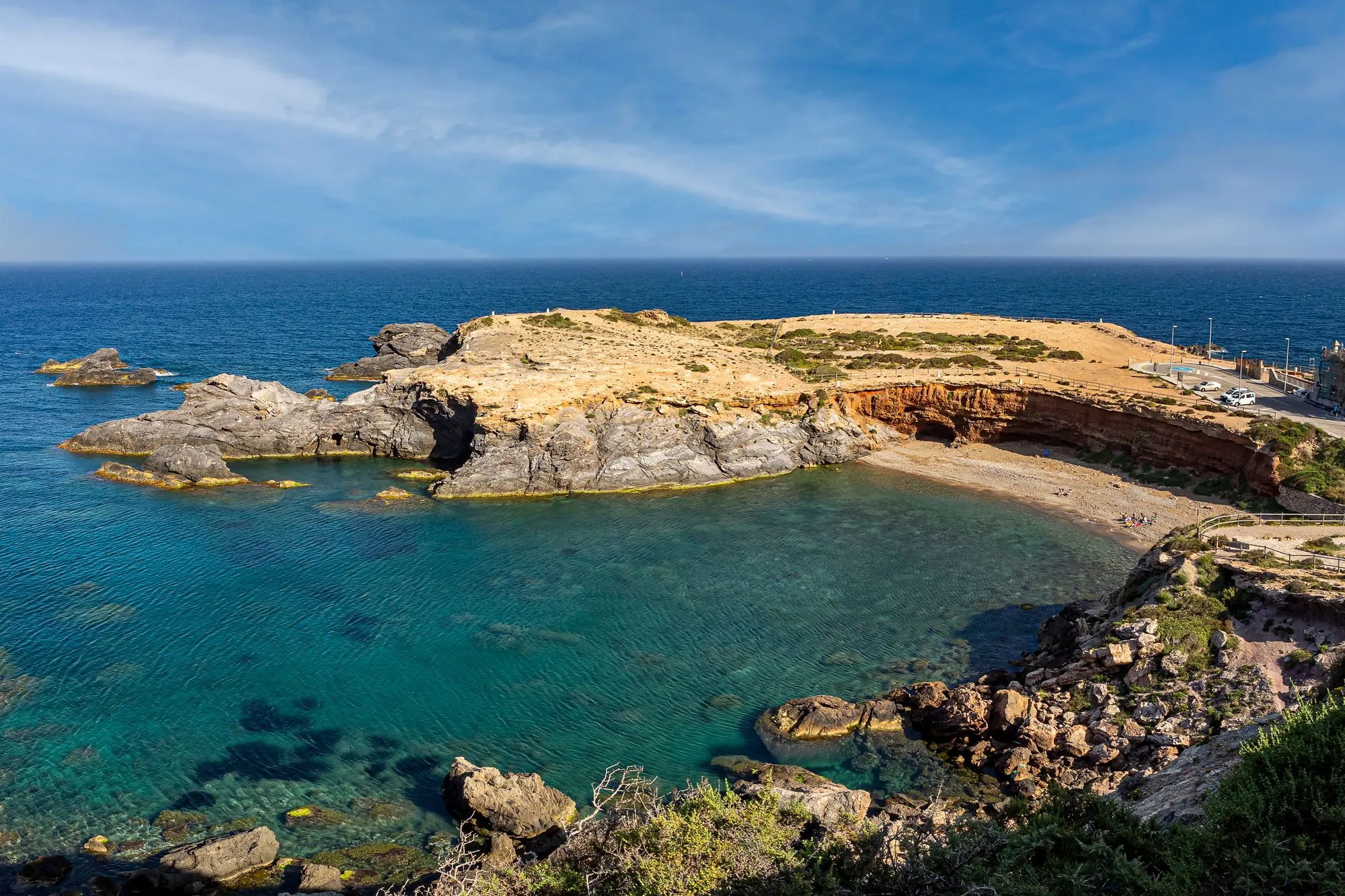 Heldere baai met rotsen en een klein strand bij Cabo de Palos